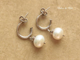 White freshwater pearls on silver hoop stud earrings.